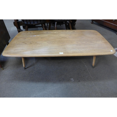 90 - An Ercol Blonde elm coffee table, on associated legs