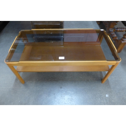 93 - A teak and glass topped coffee table