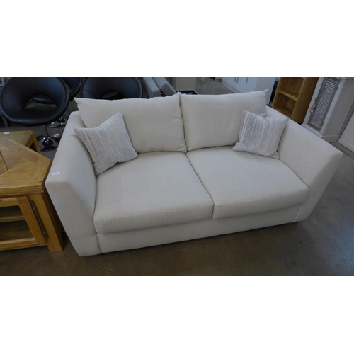 1438 - A designer cream upholstered two seat sofa (slightly marked)