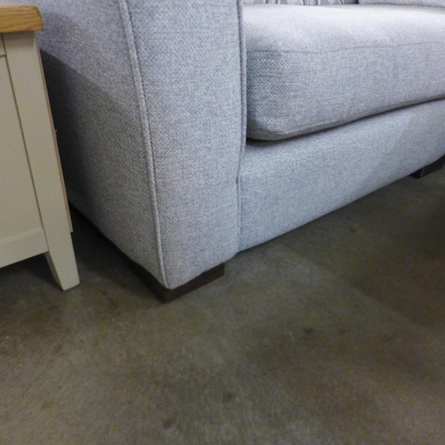 1307 - A designer grey upholstered corner sofa with footstool (different feet on footstool)