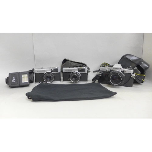 719 - An Olympus OM10 35mm camera, two Olympus Trip 35 cameras and flash