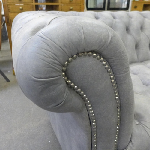 1313 - A grey leather large two seater Chesterfield sofa (minor scuff to rear corner )