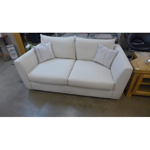 1395 - A designer cream upholstered two seat sofa (slightly marked)