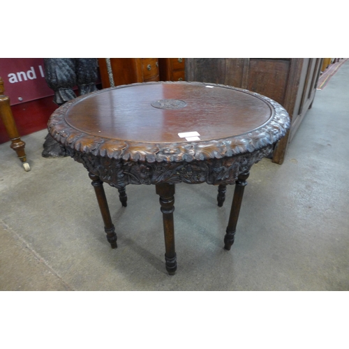 15 - An early 20th Century carved oak revolving circular occasional table