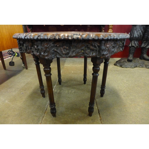 15 - An early 20th Century carved oak revolving circular occasional table