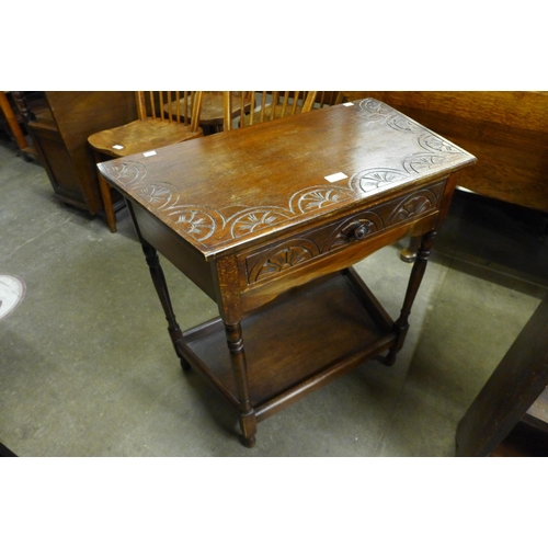 152 - A carved oak single drawer side table