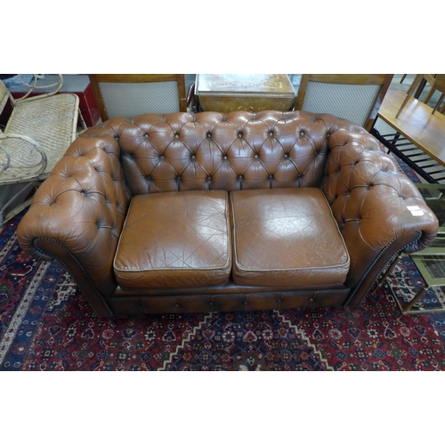 42 - A brown leather Chesterfield settee