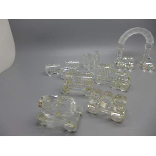 671 - A Swarovski crystal model train with arch and other glass model trains, with two stands