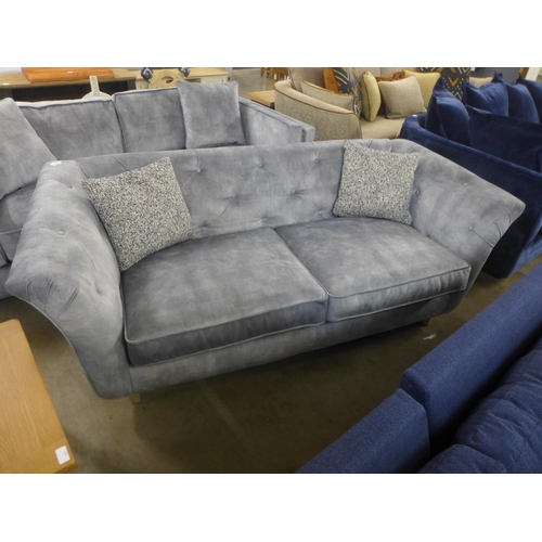 1319 - A grey velvet button back three seater sofa