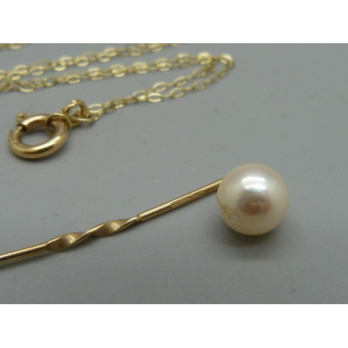 1012 - A 9ct gold cross pendant on chain, 2.4g, and a hallmarked 9ct gold and pearl stick pin, 0.7g