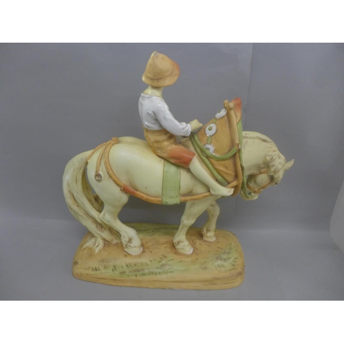 602 - Manner of Royal Dux; large figure of a young boy on horseback, 39cm