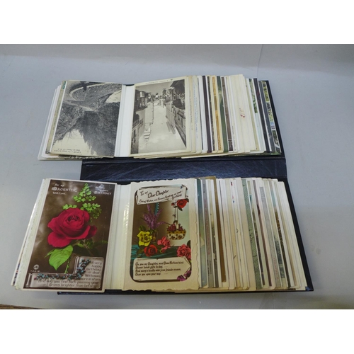 701 - An album of early to mid 20th Century postcards, including three silk