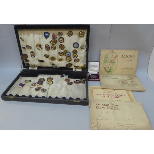 706 - A collection of vintage enamel pin badges, a medallion and a collection of cigarette card albums