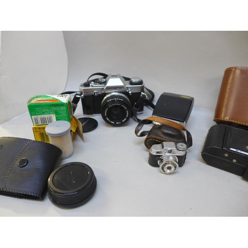 730 - Cameras and accessories including an Olympus OM20 body, a Polaroid and a miniature novelty camera