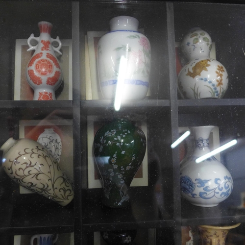 817 - Oriental style miniature vases in a display case