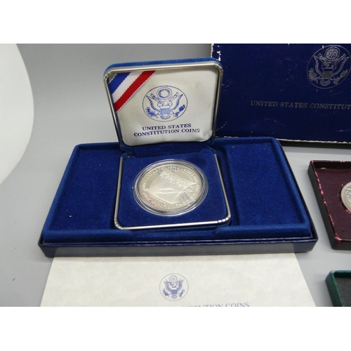 903 - A 1987 US silver dollar, cased, a British Legion commemorative medallion, cased, a Churchill crown, ... 