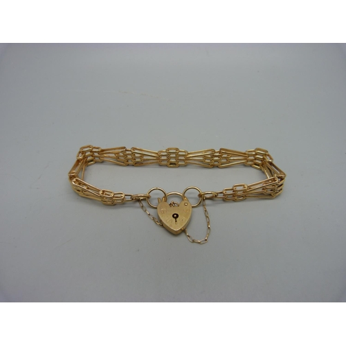 945 - A 9ct gold gate bracelet with padlock fastener and safety chain, 15.7g