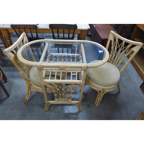 106 - A bamboo and glass topped table and two chairs