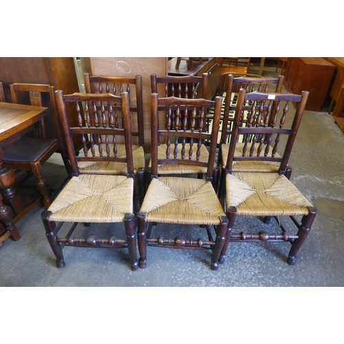 169 - A set of six Georg III style elm and ash spindle back rush seated chairs