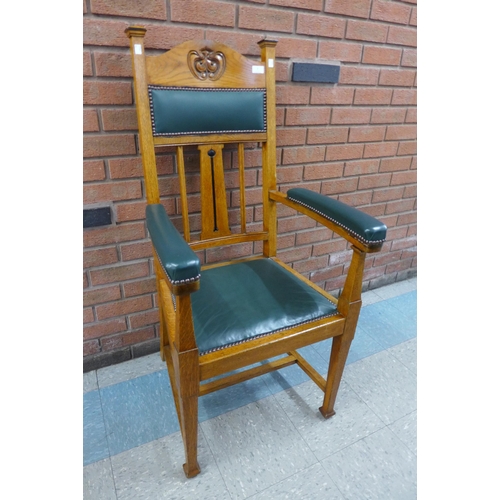 2 - An Arts and Crafts carved oak and green leather armchair