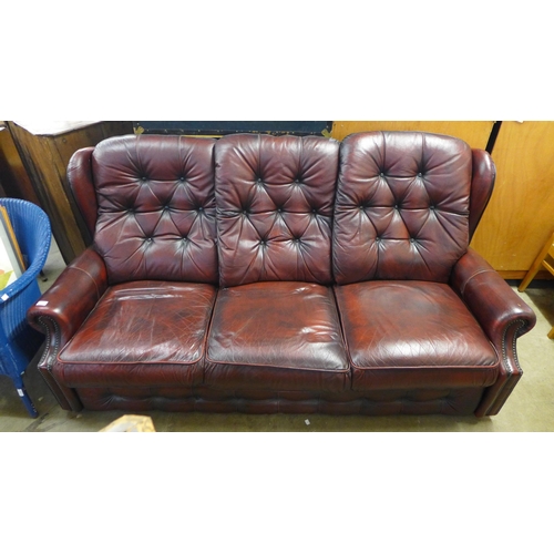 247 - A burgundy leather buttoned sofa