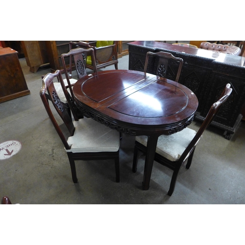 35 - A Chinese hardwood extending dining table and six chairs