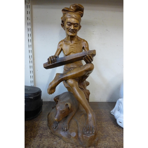 388 - An oriental carved hardwood figure of a man and dog