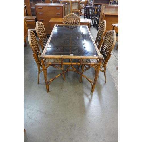 72 - A bamboo and glass topped dining table and six chairs