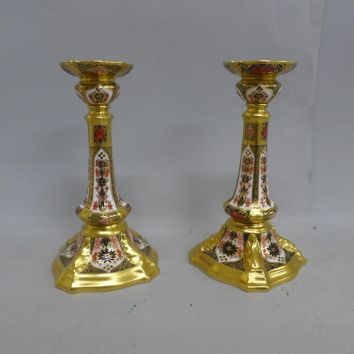 603 - A pair of Royal Crown Derby Old Imari candlesticks, one with small hairline to base, 17.5cm