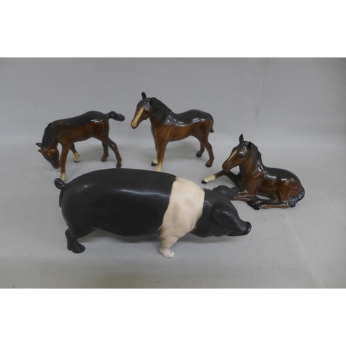 632 - Three Beswick foals and a model of a saddleback pig, one foot chipped