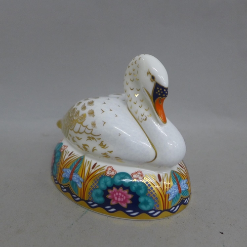 672 - A Royal Crown Derby paperweight - White Swan nesting, date mark for 2008, gold stopper and red Royal... 