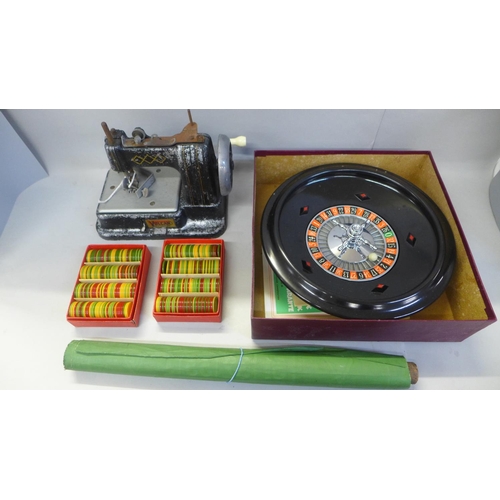 685 - A roulette wheel, counters and a Vulcan metal toy sewing machine