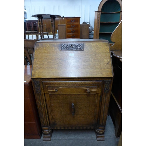 125 - An Art Deco carved oak bureau