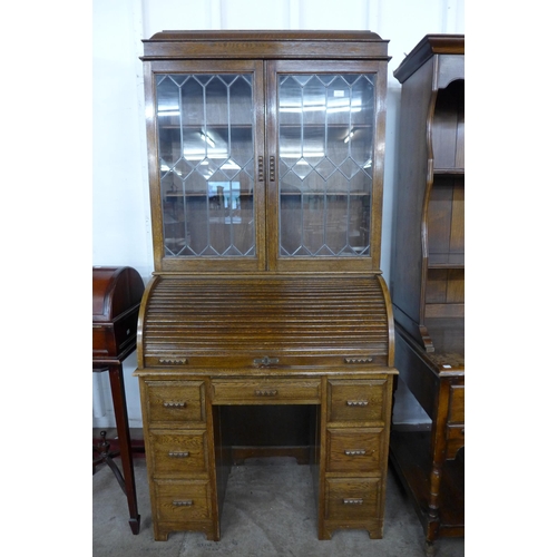 132 - An oak bookcase on tambour roll-top desk (tambour desk locked - no key)