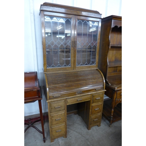 132 - An oak bookcase on tambour roll-top desk (tambour desk locked - no key)