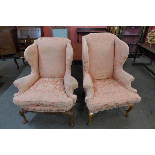 14 - A pair of similar Queen Anne style walnut and fabric upholstered wingback armchairs