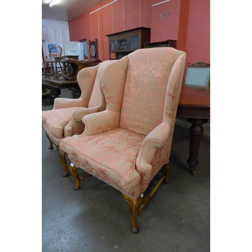 14 - A pair of similar Queen Anne style walnut and fabric upholstered wingback armchairs