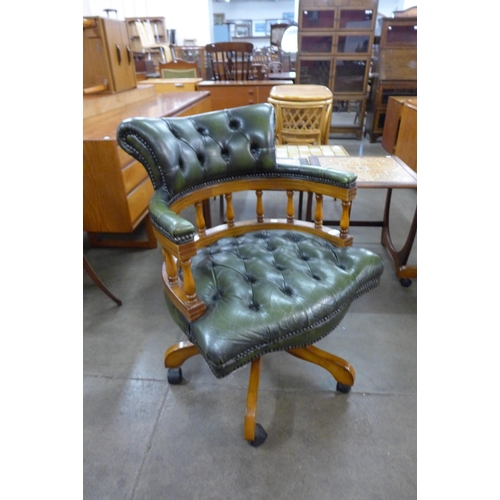 18a - A mahogany and green leather revolving desk chair