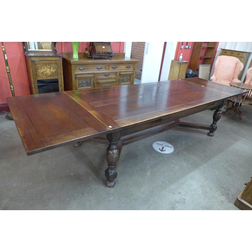 4 - A 17th Century style oak extending refectory table, 75cms h, 228cms l (348cms l extended), 106cms w