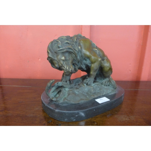 401 - A bronze figure of a lion fighting a snake, on black marble plinth