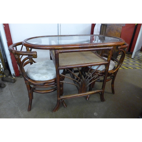 85 - A bamboo, rattan and glass topped table and two chairs