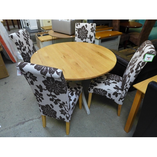 1668 - An oak circular dining table and four upholstered floral chairs