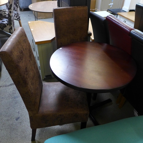 1678 - A dark circular table and two light brown chairs