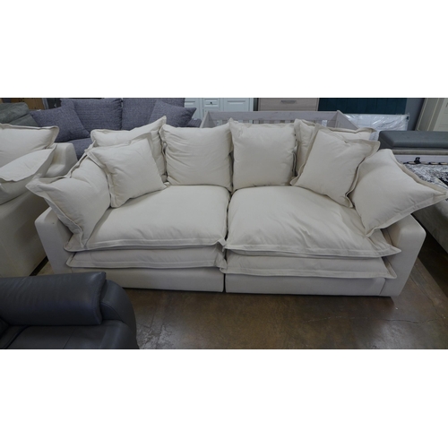 1528 - A designer three seater sofa, armchair and footstool, in natural brushed cotton (has minor handling ... 