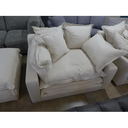 1528 - A designer three seater sofa, armchair and footstool, in natural brushed cotton (has minor handling ... 