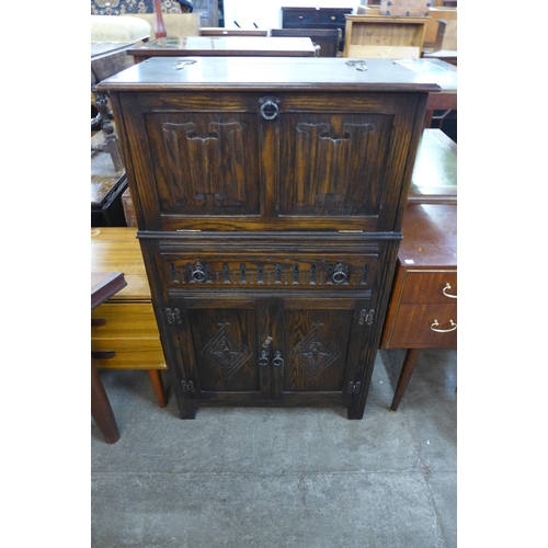 116 - A carved oak linenfold cocktail cabinet