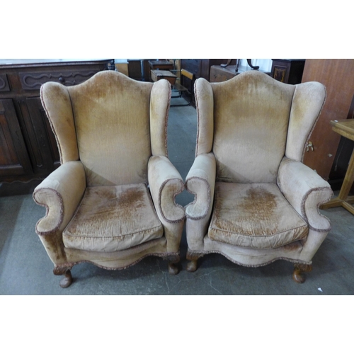 128 - A pair of George I style walnut and fabric upholstered wingback armchairs