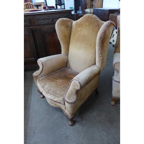 128 - A pair of George I style walnut and fabric upholstered wingback armchairs