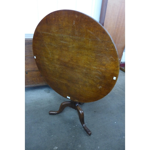 130 - A George III oak circular tilt-top tripod tea table