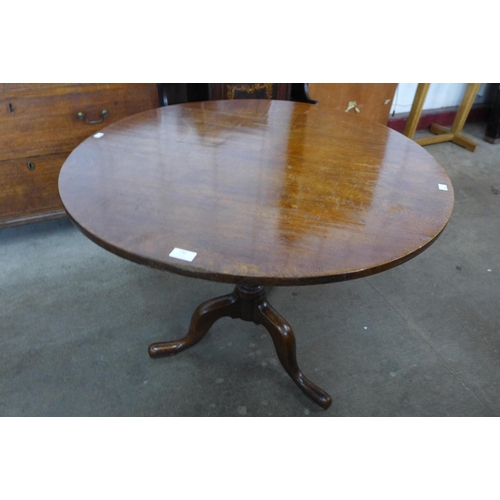 130 - A George III oak circular tilt-top tripod tea table